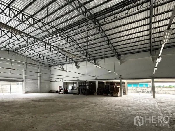 Warehouse for rent in Bang Khun Thian, Bangkok - Spacious warehouse interior with high steel truss ceiling, concrete floor, and open loading access.