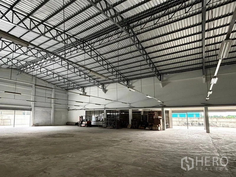 Warehouse for rent in Bang Khun Thian, Bangkok - Spacious warehouse interior with high steel truss ceiling, concrete floor, and open loading access.