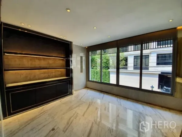 Office Space for rent in Khlong Toei, Bangkok - Corner meeting room with illuminated black built-in shelving and wide windows.