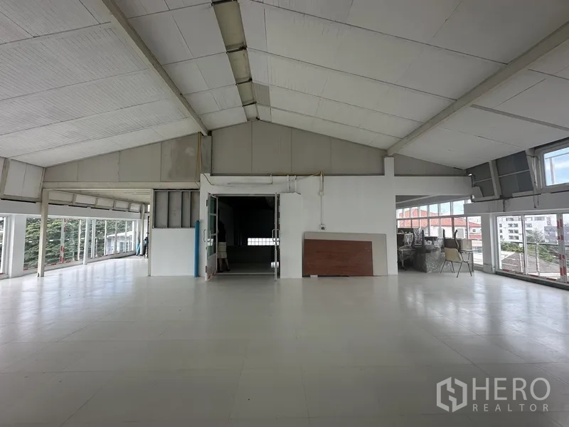 Office Space for rent or sale - Top-floor workspace with vaulted insulated ceiling and wide windows.