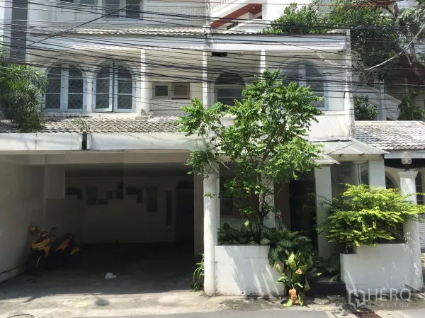 พื้นที่ขายปลีก ให้เช่าในWatthana, Bangkok - อาคารหน้าติดถนนสีขาวทรงโลว์ไรส์ หน้าต่างโค้ง มีที่จอดรถในร่มและสวนกระถาง เหมาะทำร้านค้า ใกล้ BTS ทองหล่อ.