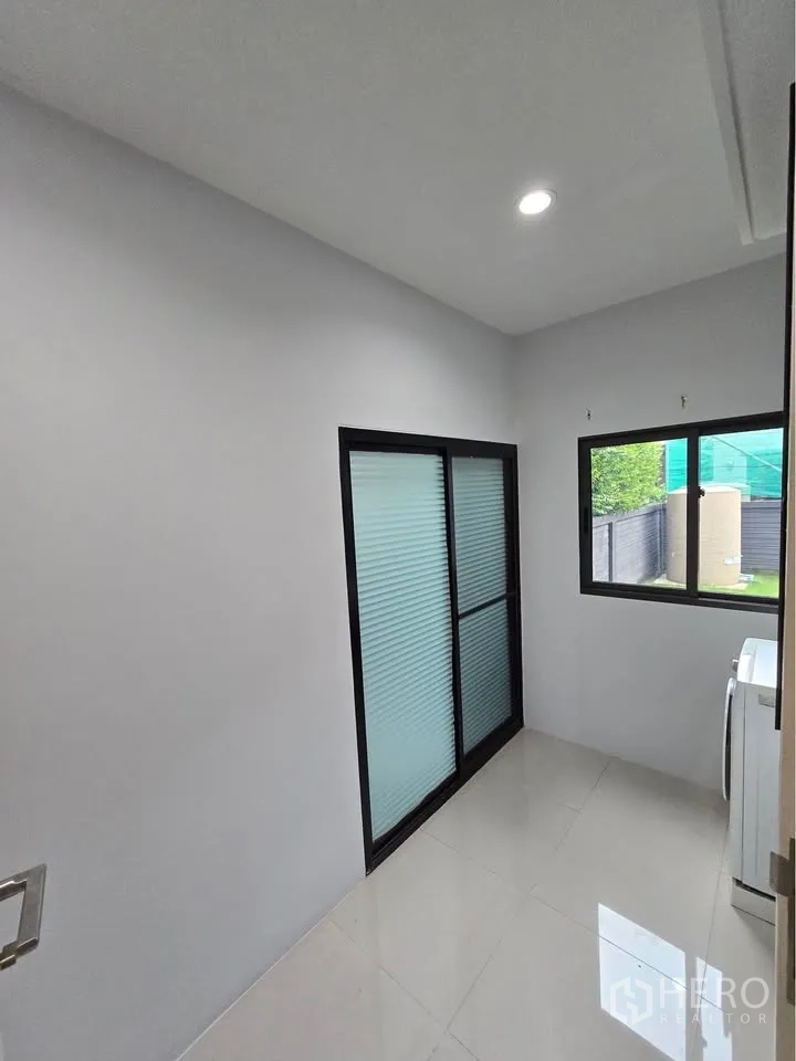 บ้านเดี่ยว for rent in Bang Kapi, Bangkok - ห้องเล็กสว่างพร้อมประตูกระจกบานเลื่อนและหน้าต่างมองสู่สวน