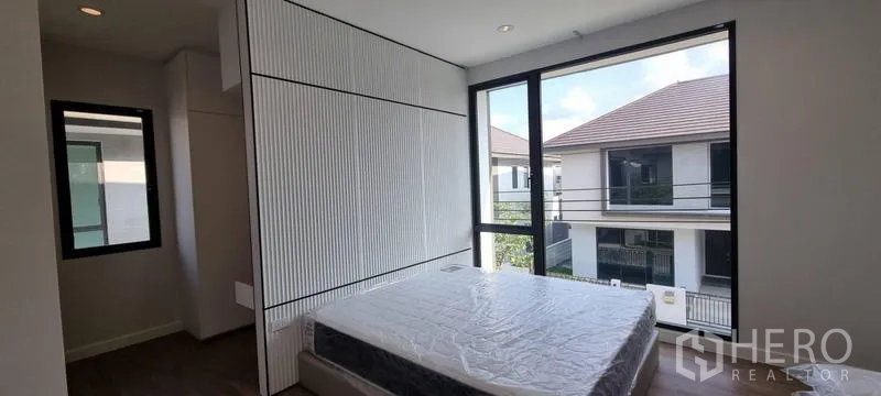 บ้าน ให้เช่าในSaphan Sung, Bangkok - ห้องนอนสว่างด้วยกระจกมุมเต็มผืนและผนังหัวเตียงลายเซาะร่อง