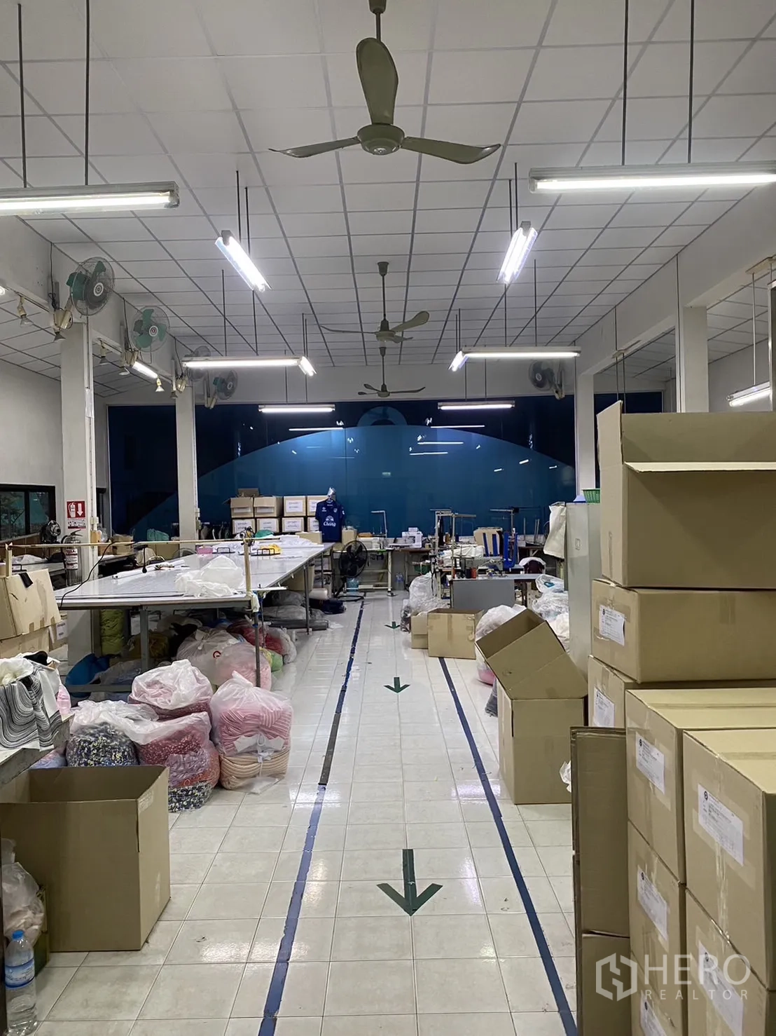 工厂 出租在Prawet, Bangkok - 生产线中央通道，地面方向箭头与堆放的纸箱物料