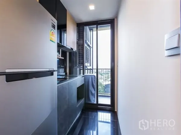 公寓 出租在Chatuchak, Bangkok - 狭长厨房，内置橱柜与大冰箱，通向阳台可观市景。