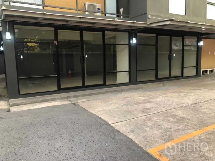 办公空间 出租在Phaya Thai, Bangkok - 建筑外立面长条玻璃门面与车道出入口，便于到达。