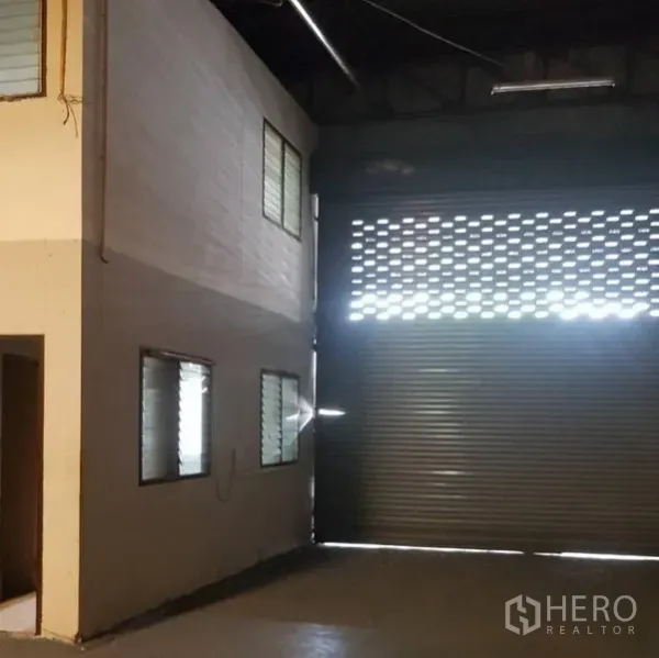 货栈 出租在Khlong Luang, Pathum Thani - 仓库内景，宽大卷闸门、夹层办公室与百叶窗