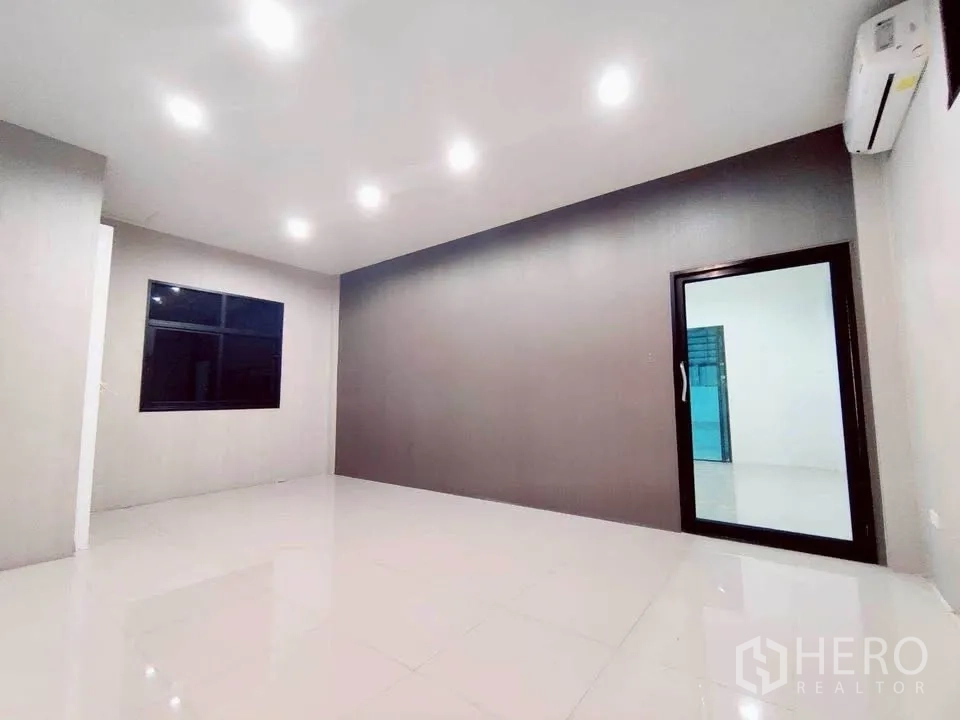 Warehouse for rent in Lam Luk Ka, Pathum Thani - Second office room with downlights, dark feature wall and glazed door.