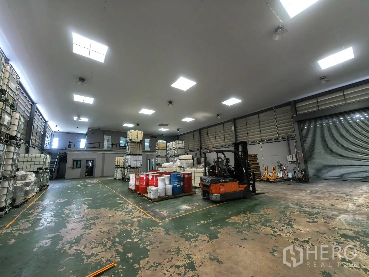 Warehouse for rent in Bang Sao Thong, Samut Prakan - Wide view of open warehouse area with bright lighting and roller doors.