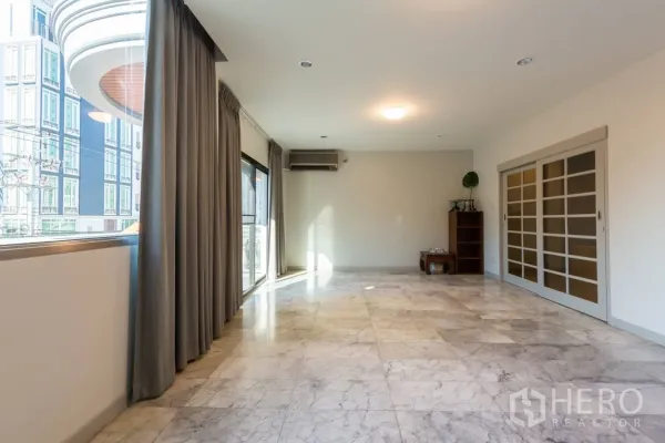 带办公室的家 出租在Bang Rak, Bangkok - 采光充足的客厅，大理石地面，落地窗与推拉门通往阳台。