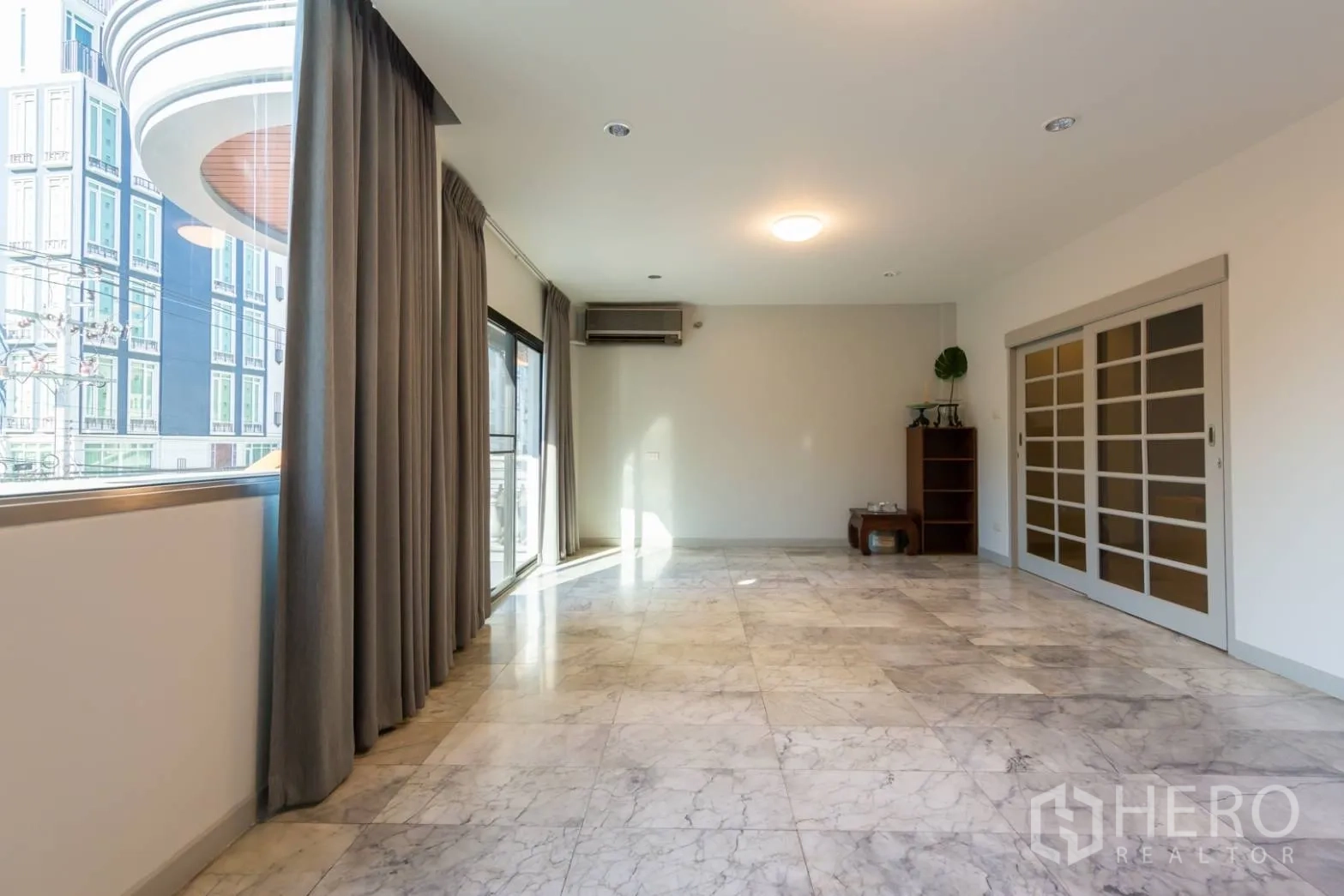 带办公室的家 出租在Bang Rak, Bangkok - 采光充足的客厅，大理石地面，落地窗与推拉门通往阳台。