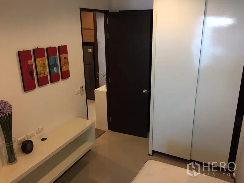 คอนโด ให้เช่าในKhlong Toei, Bangkok - ภายในห้องนอนรองพร้อมตู้เสื้อผ้าเงาและประตูเข้าสู่โถง