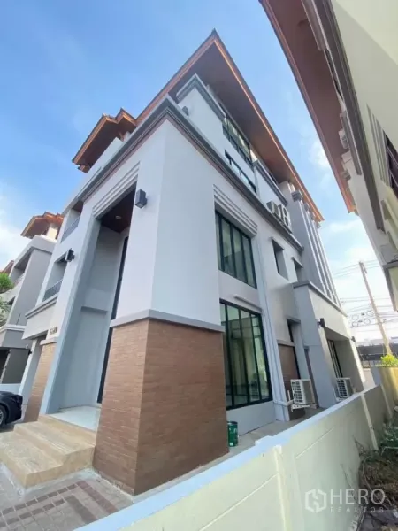 Home Office for rent in Wang Thonglang, Bangkok - Side perspective of the corner building showing large windows and brick-clad base.