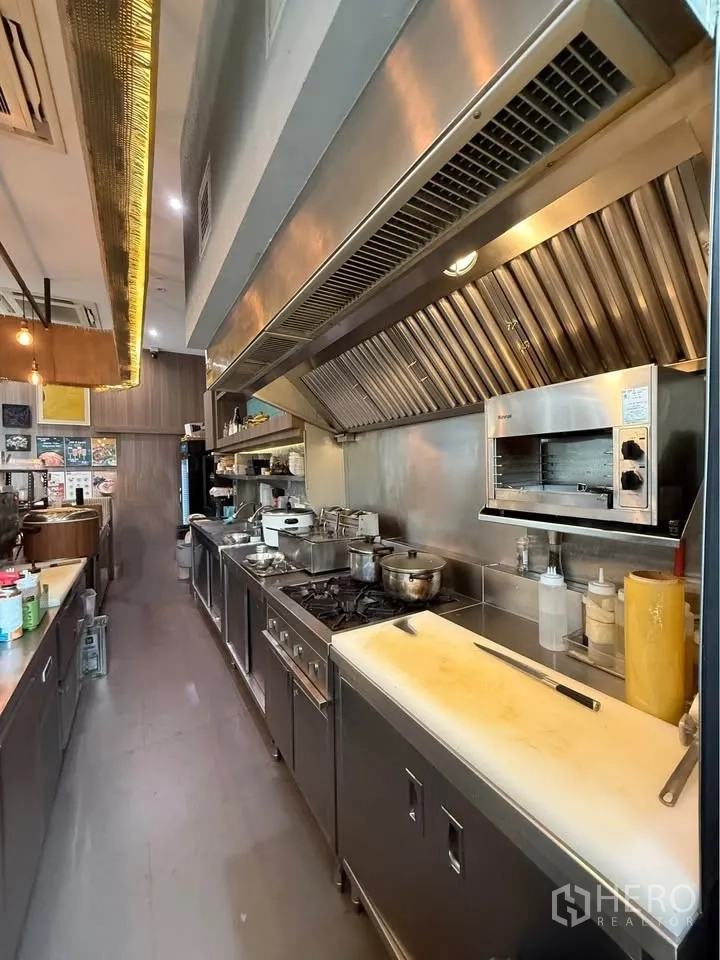 Retail Space for rent in Watthana, Bangkok - Commercial kitchen line with gas hobs, oven, and an overhead exhaust hood.