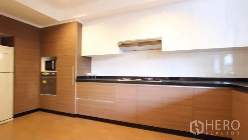 อพาร์ทเมนท์ ให้เช่าในKhlong Toei, Bangkok - มุมครัวอีกด้าน โชว์เตาบิวท์อิน ไมโครเวฟติดผนัง และตู้เก็บของมากมาย