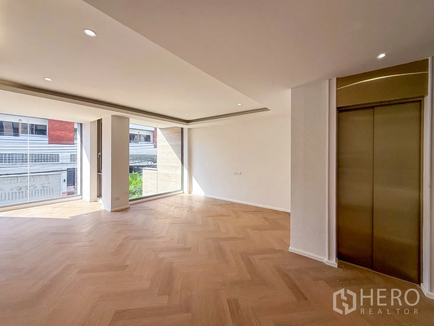 家庭办公室 for rent or sale in Watthana, Bangkok - 转角空间配大面积玻璃与金色电梯门。