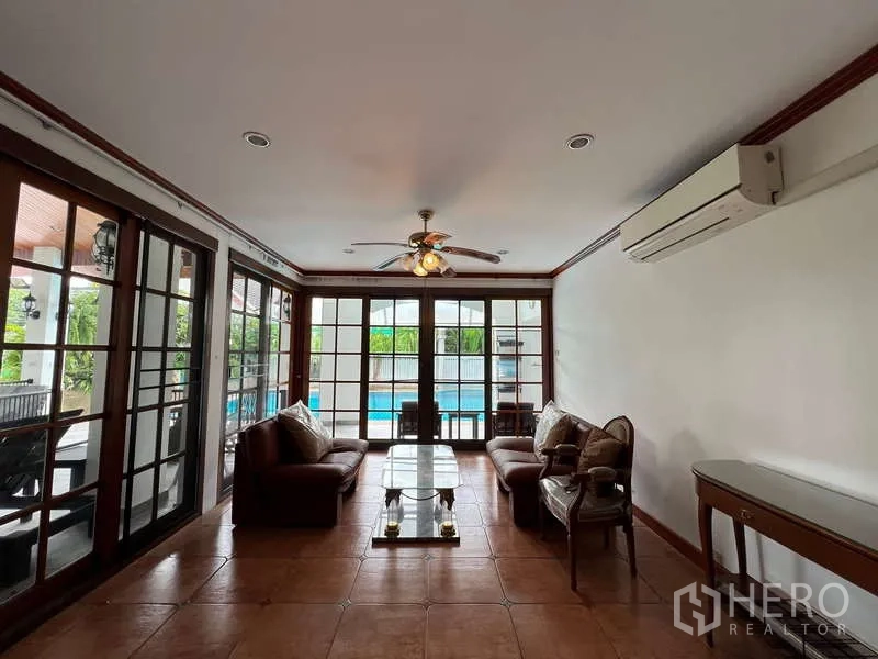 Detached House for rent in Chatuchak, Bangkok - Poolside family room with glass doors, ceiling fan and tiled floor.