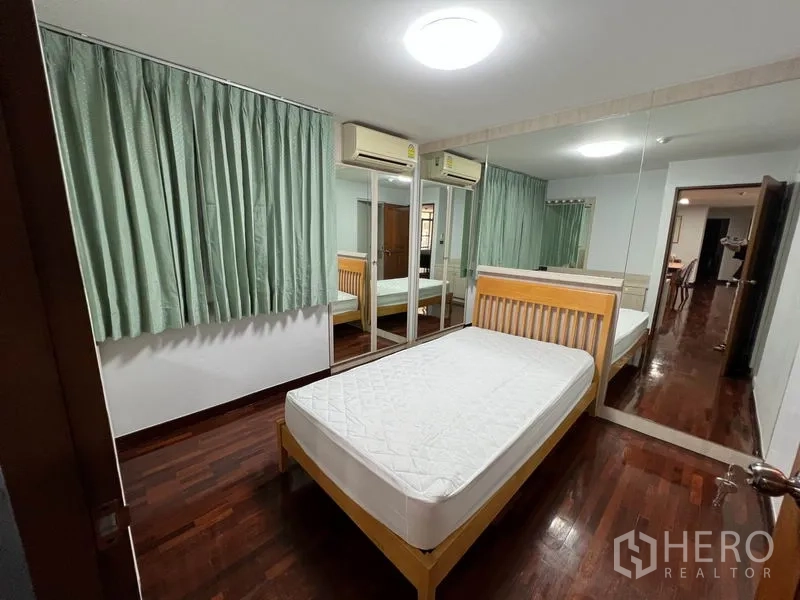 公寓 出租或出售在Watthana, Bangkok - 卧室配单人床，绿色窗帘，镜面衣柜与双空调。