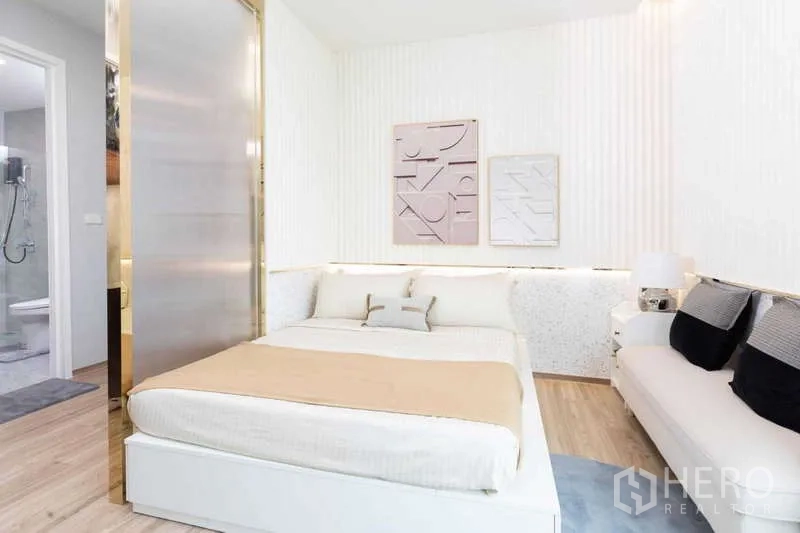 บ้าน ให้เช่าหรือขายในLat Krabang, Bangkok - ห้องนอนสำหรับแขก โทนสีอ่อน พร้อมโซฟา และทางเข้าห้องน้ำในตัว