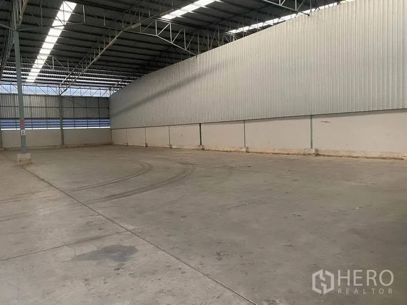 Warehouse for rent in Lat Krabang, Bangkok - Clear-span warehouse interior with tall roof and wide maneuvering space on concrete flooring.