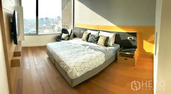 คอนโด ให้เช่าในPathum Wan, Bangkok - ห้องนอนรับแสงด้วยหน้าต่างบานใหญ่ พื้นไม้ และวิวเมืองกว้าง