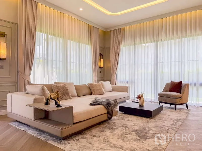 Detached House for rent or sale in Bang Kapi, Bangkok - Lounge area with oversized sofa, coffee table and floor-to-ceiling windows.
