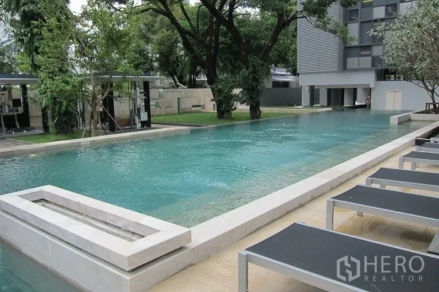 Condominium for rent or sale in Watthana, Bangkok - Lap pool with sun loungers at a modern Thonglor condo in Watthana, Bangkok.