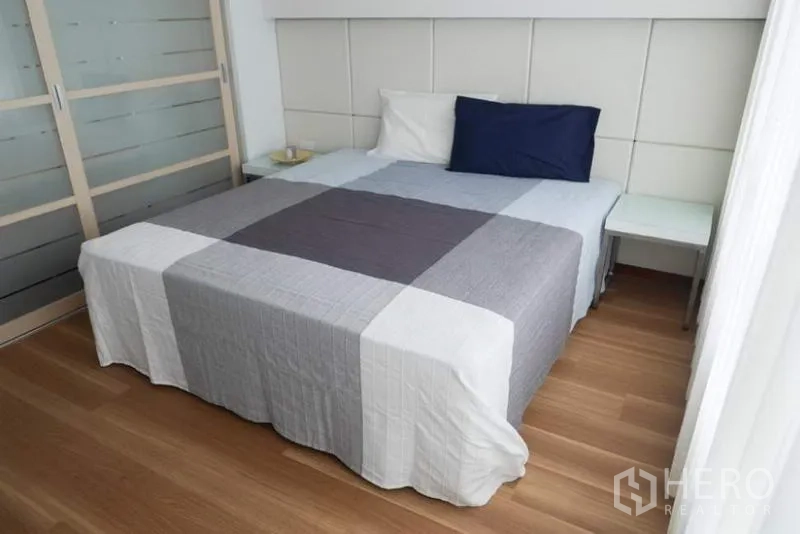 Condominium for rent in Pathum Wan, Bangkok - Primary bedroom with king bed, wood flooring and sliding wardrobe in a Bangkok Pathum Wan condominium.