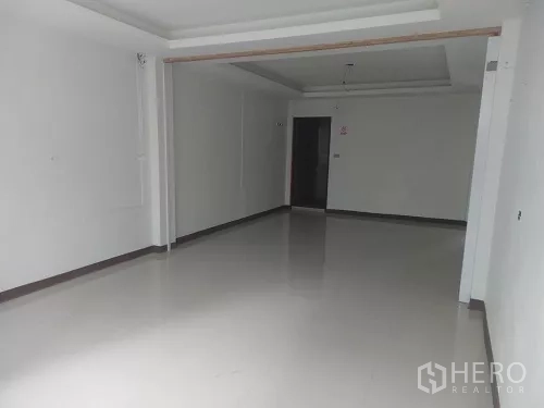 Shophouse for rent in Bang Rak, Bangkok - Mid-floor room with drop ceiling, a single doorway and clean white walls.