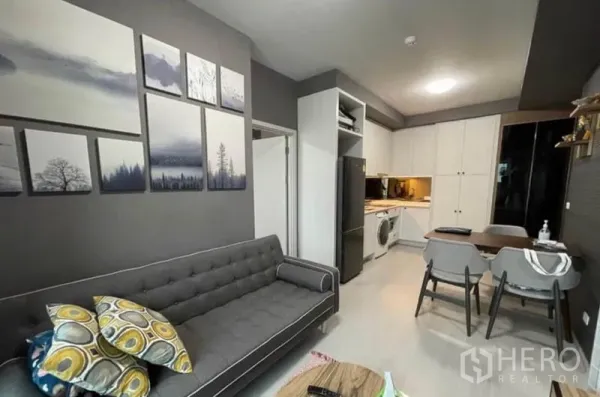 Condominium for sale in Bang Sue, Bangkok - Living room wall art beside compact dining space and a built-in kitchen.