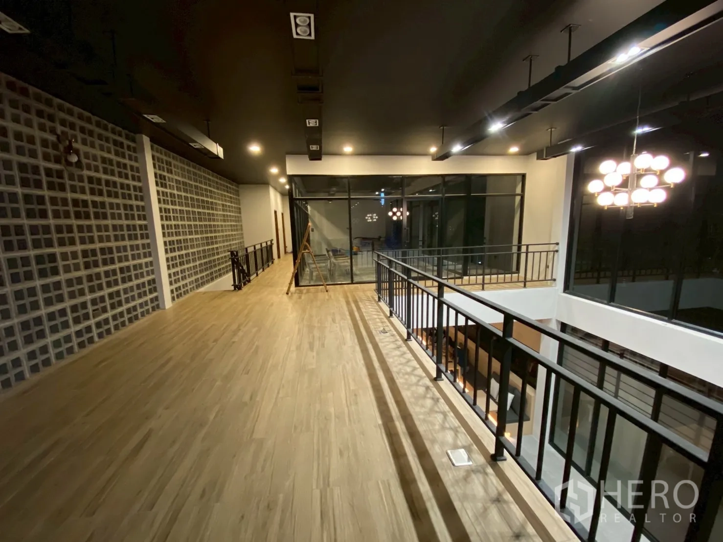 Detached House for sale in Mueang Nakhon Pathom, Nakhon Pathom - Second-floor corridor with glass wall panels, wooden-look flooring and ceiling lights.