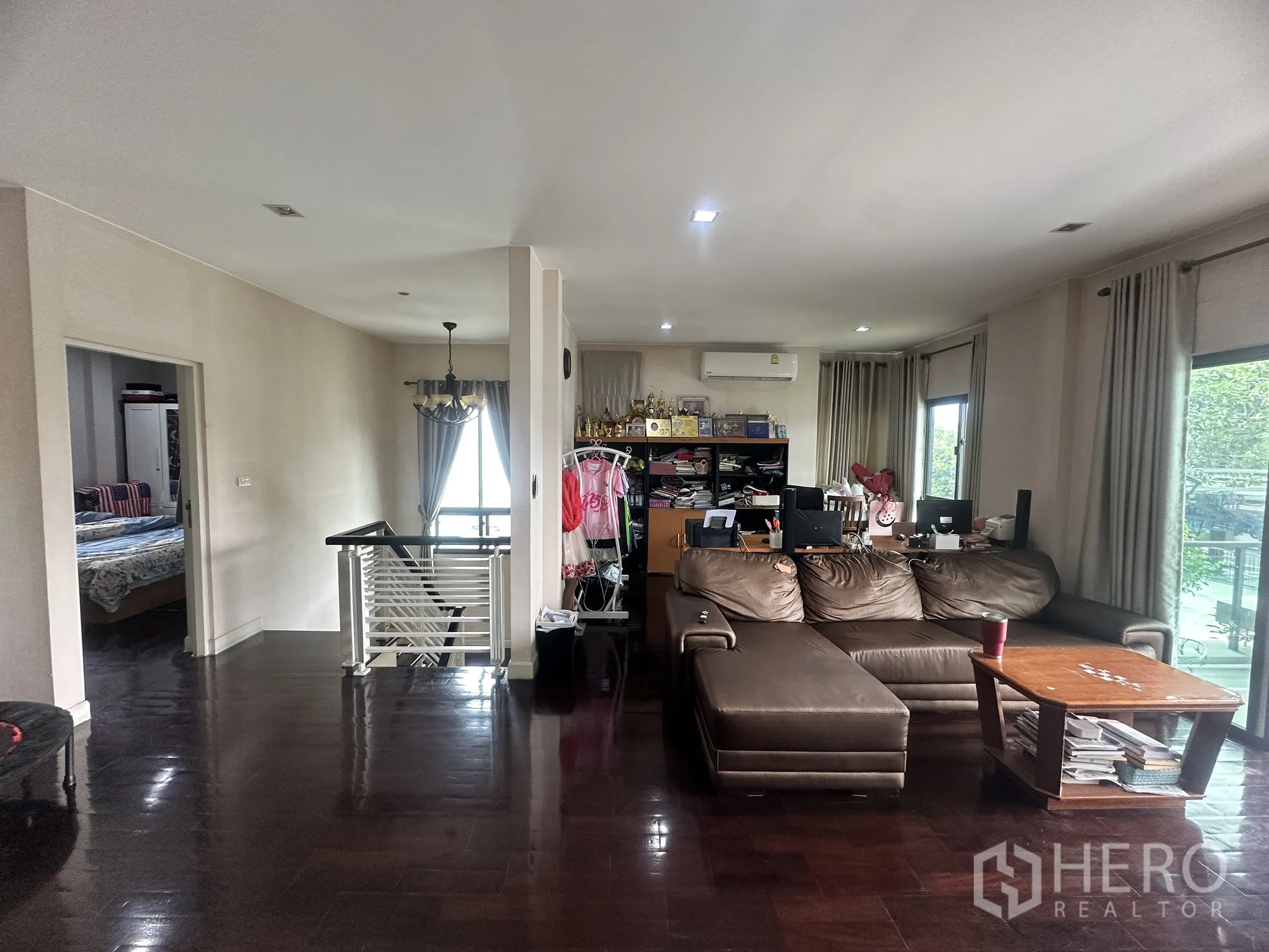 Detached House for sale in Pak Kret, Nonthaburi - Upstairs family lounge with L-shaped sofa, windows, and stair railing.