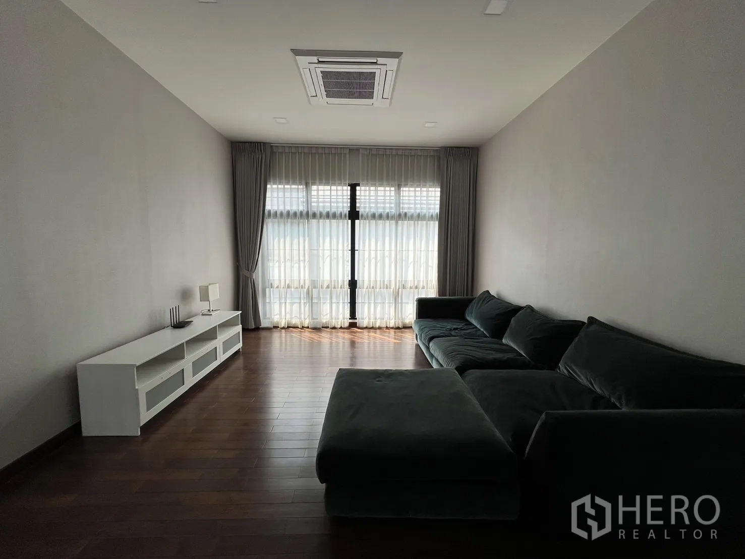 Detached House for rent or sale in Prawet, Bangkok - Second view of family lounge with long sofa and media console.