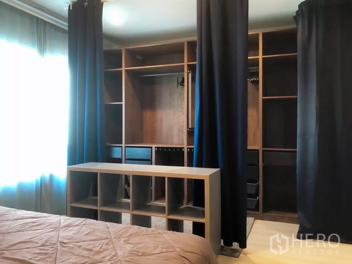 Townhouse for rent or sale in Bang Phli, Samut Prakan - Bright second bedroom with bed, study desk, open wardrobe and rug.