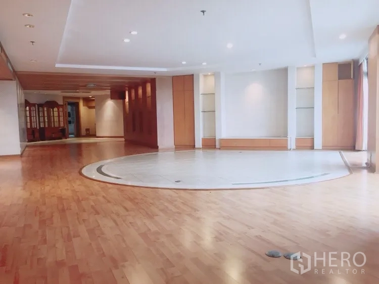 Condominium for rent in Watthana, Bangkok - Open-plan living space with a circular tiled centerpiece and recessed lighting.