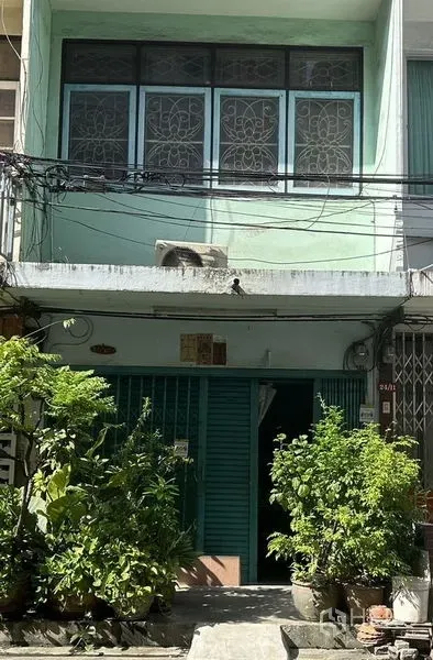 อาคารพาณิชย์ ให้เช่าหรือขายในWatthana, Bangkok - ด้านหน้าตึกแถวสองชั้นสีเขียวมิ้นท์ ประตูเหล็กม้วนและกระถางต้นไม้