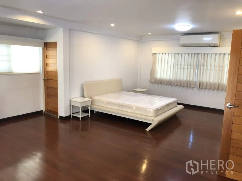 Detached House for rent in Suan Luang, Bangkok - Large master bedroom with wood flooring, bed frame and air conditioner