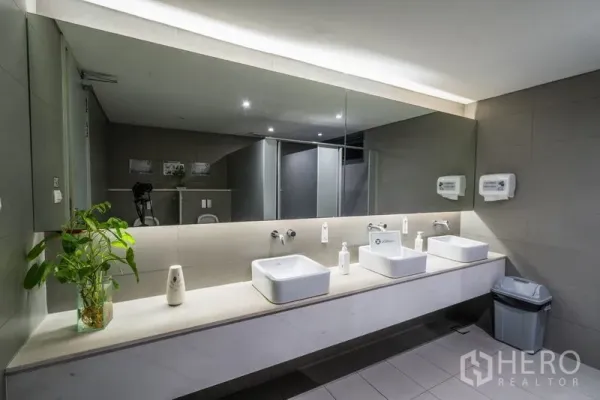สำนักงาน ให้เช่า - เคาน์เตอร์อ่างล้างหน้า 3 อ่าง กระจกบานยาว และเครื่องจ่ายสบู่ในห้องน้ำออฟฟิศ