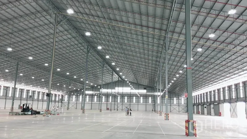 货栈 出租在Si Racha, Chon Buri - 开阔的仓库地面，展示高净空、采光带与钢柱。