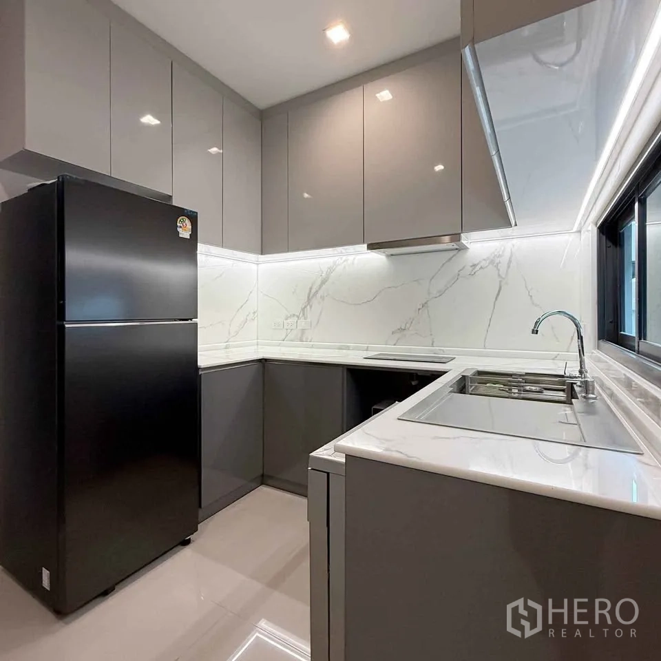 Detached House for rent in Bang Phli, Samut Prakan - Alternate angle of the kitchen showing fridge, sink and ample cabinets.