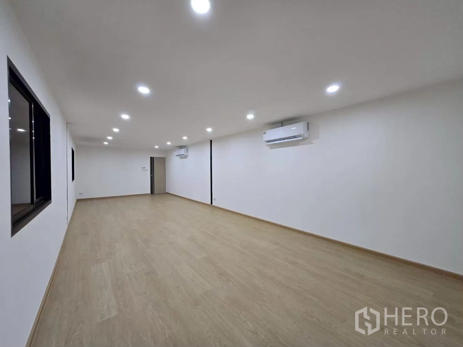 Warehouse for rent in Suan Luang, Bangkok - Bright air‑conditioned office room with wood‑tone flooring and recessed LED lighting inside the warehouse.