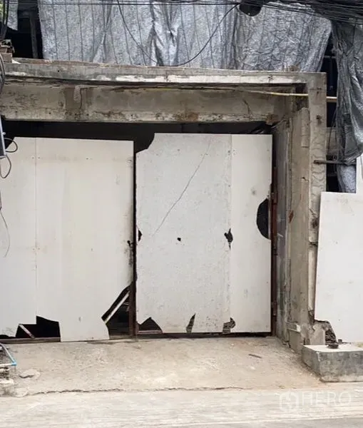 零售空间 出租在Watthana, Bangkok - 素坤逸核心区街边店面，混凝土门框与白色临时围挡，店铺处于翻新阶段。