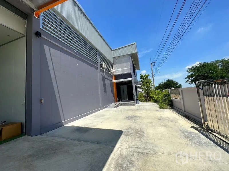 โรงงาน ให้เช่าหรือขายในLam Luk Ka, Pathum Thani - ลานด้านข้างมีกำแพงรั้วและทางคอนกรีตยาวตลอดแนวอาคาร.