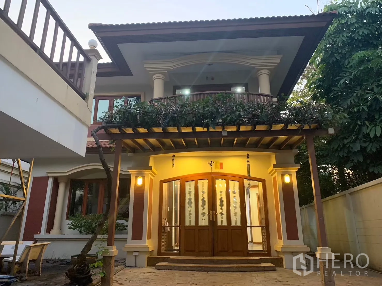 บ้าน ให้เช่าในWatthana, Bangkok - ภาพหน้าบ้านสองชั้นสไตล์คลาสสิก มีระเบียง ซุ้มไม้ และไฟสว่าง