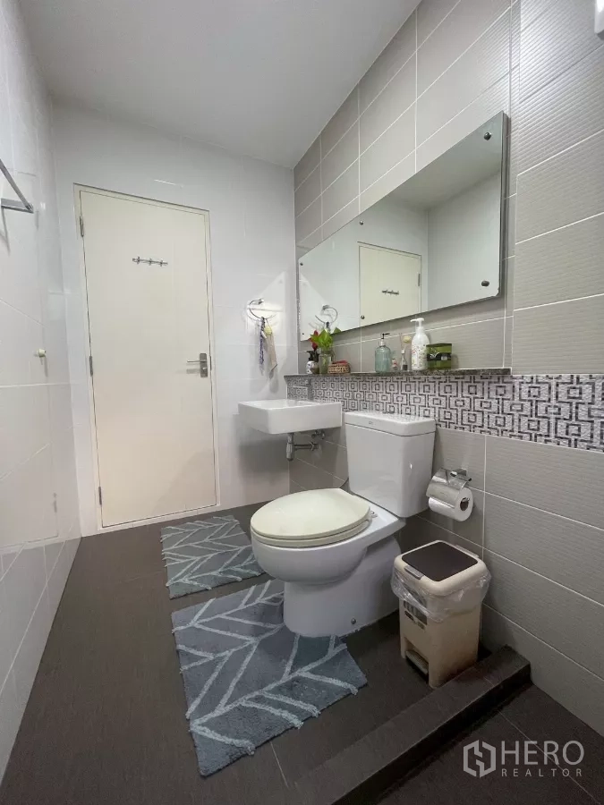Detached House for sale in Bang Phli, Samut Prakan - Bathroom with long mirror, basin, toilet and raised shower zone.