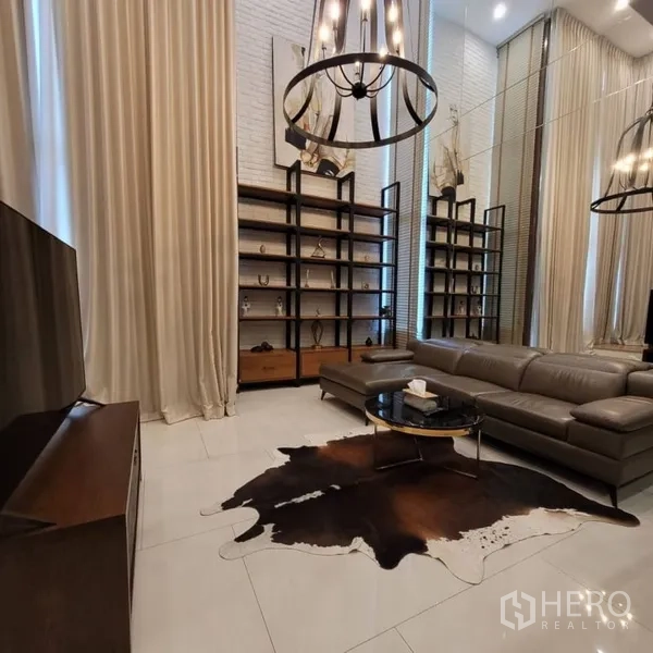 คอนโด ให้เช่าในKhlong Toei, Bangkok - ห้องนั่งเล่นอบอุ่น ชั้นวางสูง โต๊ะกลางทรงกลม และโคมไฟใต้เพดานสูง