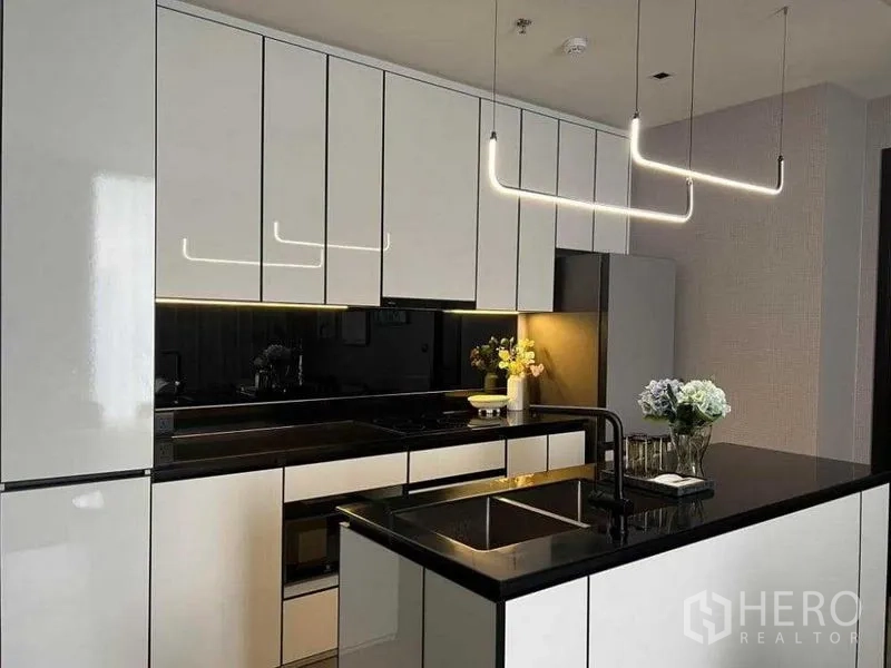 คอนโด ให้เช่าในKhlong San, Bangkok - ตู้ครัวสมัยใหม่ เคาน์เตอร์สีดำเงา และไฟเหนือไอส์แลนด์แบบมินิมอล