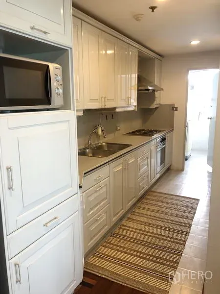 คอนโด ให้เช่าหรือขายในWatthana, Bangkok - ครัวแบบแกลลีย์ ตู้สีขาว อ่างล้างจาน เตาอบ และไมโครเวฟ