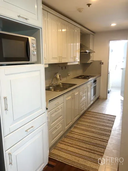 คอนโด ให้เช่าหรือขายในWatthana, Bangkok - ครัวแบบแกลลีย์ ตู้สีขาว อ่างล้างจาน เตาอบ และไมโครเวฟ