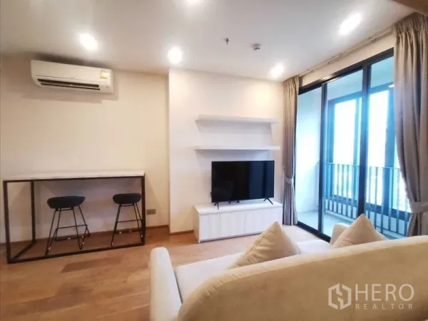 คอนโด ให้เช่าในRatchathewi, Bangkok - ห้องนั่งเล่นสว่าง พร้อมทีวี เคาน์เตอร์บาร์ และประตูกระจกเปิดสู่ระเบียง